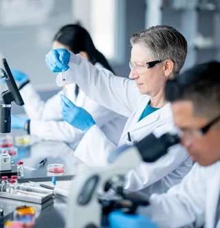 Scientists in a laboratory conducting experiments with test tubes and microscopes representing rare oncology clinical research