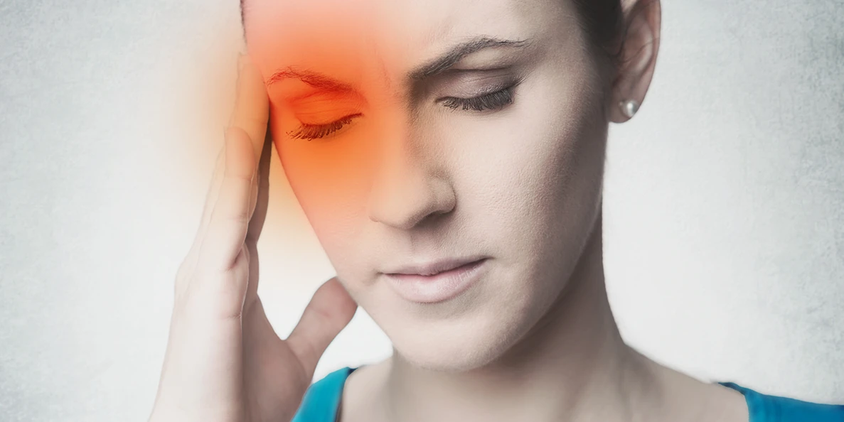 Close-up portrait of a person with eyes closed and hand pressed against their temple, with a glowing orange-red gradient overlay on the right side of their forehead